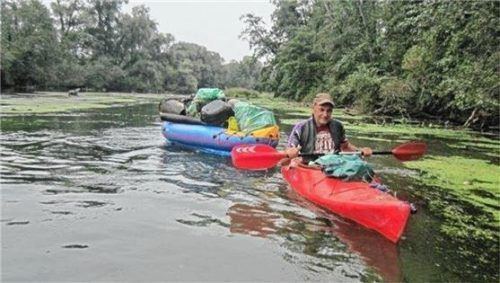 Wolfgang Matschke zieht säckeweise Müll aus dem Fluss.