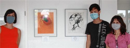 Zwei der Bilder, die im Rahmen der Ausstellung zu sehen sind, mit (von links) Christina Matousek, Projektleitung des Mehrgenerationenhauses, Künstler Philipp Müller und Förderlehrerin Hedi Bartle. Foto re