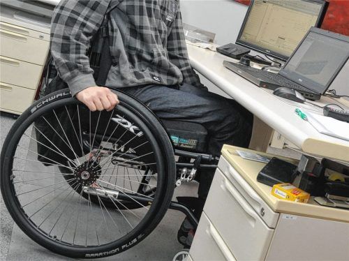 Ein Mann sitzt im Rollstuhl an seinem Schreibtisch. Sobald ein Betrieb mehr als 20 Mitarbeiter hat, muss dort mindestens ein Arbeitsplatz mit einem schwerbehinderten Mitarbeiter besetzt werden. Wenn nicht, muss er eine Ausgleichszahlung leisten.Fotos  dpa, re