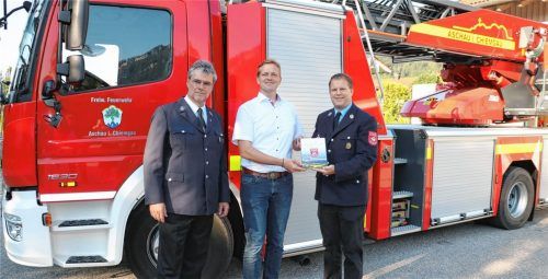 Frisch aus der Druckerpresse: Die beiden Vorsitzenden der Feuerwehr Aschau, Werner Grill (rechts) und Christian Deml (links), übergaben vor dem Aschauer Feuerwehrhaus das erste Exemplar der Festschrift zum 150. Gründungsjubiläum der Aschauer Feuerwehr an Bürgermeister Simon Frank. Foto Rehberg