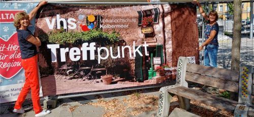 Endlich geht‘s wieder los: Monika Hofmann (links) und Birgit Margreiter von der VHS Kolbermoor hängen das Banner zum Semesterstart auf. Foto  VHS