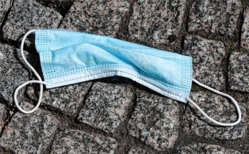Plötzlich ein vertrauter Alltagsanblick: Ein verlorener Mund-Nasen-Schutz liegt auf dem Straßenpflaster. Foto dpa