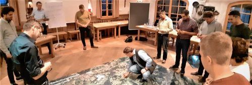 Gemeinderat Wolfgang Ull markiert im Kreise der Gemeinderatskollegen für ihn wichtige Bereiche auf dem am Boden ausgelegten Luftbild vom Samerberg.Foto re