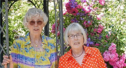Mindestens zwei Stunden täglich sind sie mit der Pflege der Pflanzen beschäftigt: Marie (links) und Agnes Abele vor ihrem Rosenpavillon. Foto Kirchner