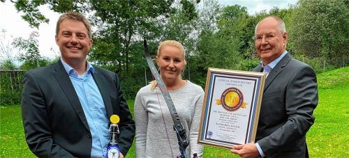 Treffsichere Bogenschützin: Katharina Bauer aus Raubling öffnete mit Pfeil und Bogen Bügelverschluss-Flaschen. Georg Holzner, Vorsitzender der Raublinger Bogenschützen (links), und Günter Bugl (rechts) gratulierten zum neuen Weltrekord. Fotos BSG Raubling