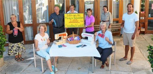 Vorsitzende  Stephanie Riedl (rechts am Plakat) übergab im Kreise der Näherinnen Maria Wenzel, Barbara Spiegel, Maria Estner, Anni Kamysek (sitzend) und Inge Murr (von links) den Erlös aus der Masken-Nähaktion an Bürgermeister Christian Glas (Dritter von links). Foto re