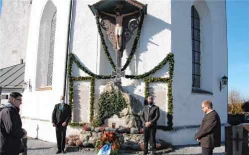 Bei der Kranzniederlegung am Ehrenmal mit dem restaurierten Kreuz gedenken (von links) Pfarrer Christoph Rudolph, Hans Heibler, Martin Perret und Florian Paul.Foto re