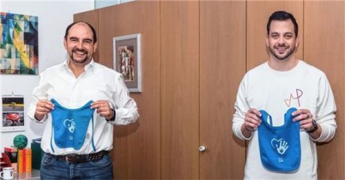 Bürgermeister Daniel Wendrock (links) und Jungunternehmer Marcel Pumpe (rechts) bei der Vorstellung der „Willkommen-Lätzchen“ im Rathaus.Foto re