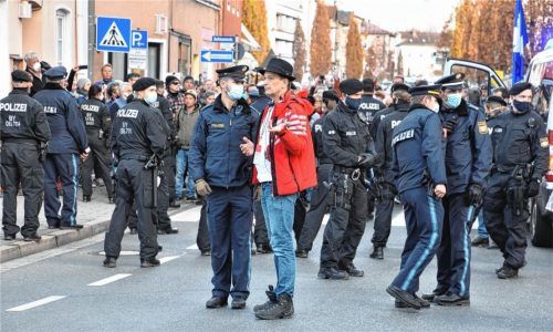 Dr. Bodo Schiffmann (Mitte), ein bekannter Kritiker der Corona-Beschränkungen, diskutiert mit der Polizei über den spontanen Spaziergang durch Rosenheim. Foto Schlecker