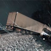 Sattelzug rutscht bei Schnee in die Leitplanke