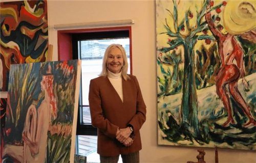 Die Malerin Katharina Daxlberger in ihrer Galerie hoch über den Dächern Rosenheims. Rechts neben ihr das Bild „Der Sonne entgegen“. Foto Seeberg