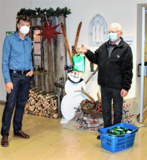 Heuer enden die Weihnachtsbesuche des Rauchclubs Kolbermoor auf den Gängen: Helmut Feuerer (rechts) übergibt ein Packerl für einen Bewohner an Jakob Hartmann, Leiter des Caritas-Altenheims St. Franziskus.Foto Riediger