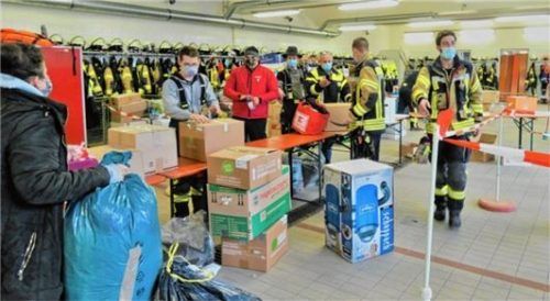 Verpacken wie am Fließband: Mitglieder der Feuerwehr Großkarolinenfeld machen Pakete fertig. Foto Greiner