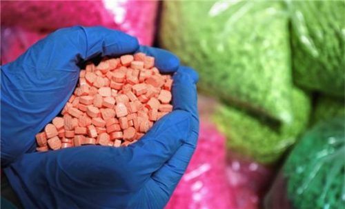 Bunt und gefährlich: Ein Zollbeamter hält Ecstasy-Tabletten in den Händen. Mit derartigen Drogen soll ein 30-Jähriger junge Leute aus dem Achental versorgt haben. Foto dpa