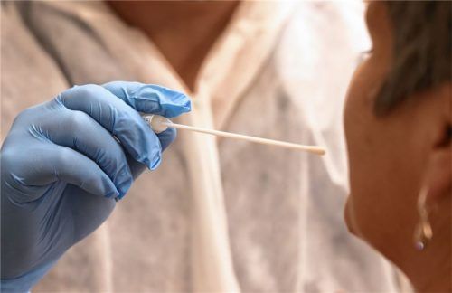 Ein Arzt nimmt per Tupfer bei einer Frau einen Abstrich für einen Corona-Test. Foto dpa