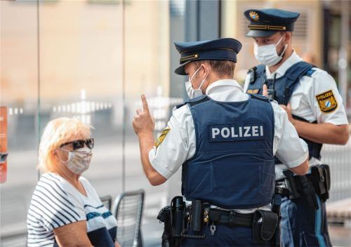Zwei Polizisten nehmen an einer Haltestelle von einer Frau nach einem Verstoß gegen die Maskenpflicht im öffentlichen Nahverkehr die Personalien auf. Die Corona-Maßnahmen sorgen bei unseren Lesern für Diskussionen. Foto dpa