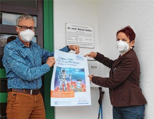 Ein Plakat, das für einen „kleinen Pieks“ wirbt: Dr. Reiner Keller und seine Frau Marianne werden es erst aufhängen, wenn für ihre Arztpraxis in Bad Aibling Impfstoff zur Verfügung steht.Foto Hadersbeck
