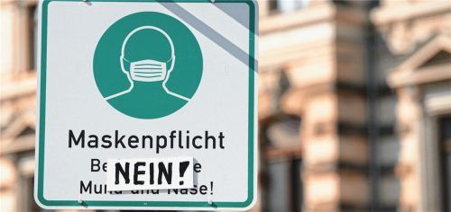 Ein überklebtes Hinweisschild für die Maskenpflicht: Symbol der gespaltenen Meinung zur Corona-Pandemie.Foto dpa