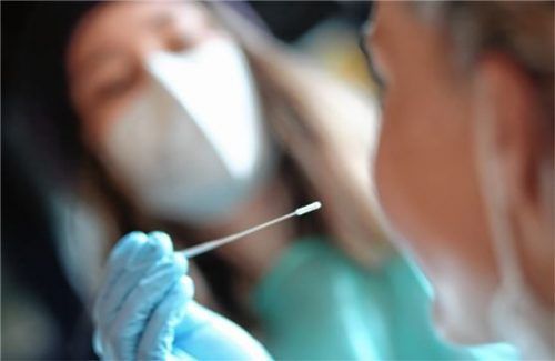 In einem Testzentrum wird einem Besucher eine Probe für einen Speicheltest abgenommen. Foto DPA