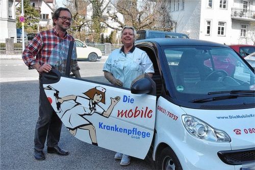 Karsten Hoeft, Chef der Mobilen Krankenpflege in Rosenheim, steht neben seiner Mitarbeiterin Claudia Pytlik, die gerade zu einem Einsatz aufbricht. Ein anderer Mitarbeiter von Hoeft konnte wegen einer 14-tägigen Quarantäne nicht arbeiten, obwohl er schon zweimal geimpft worden war. Foto Schlecker