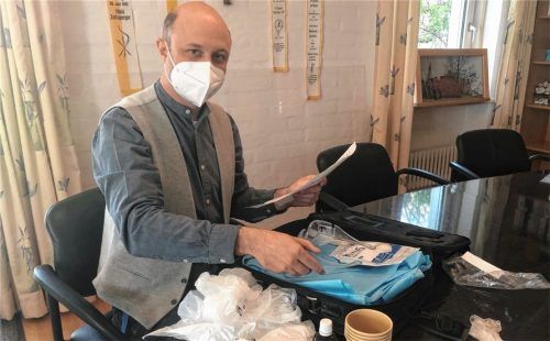 Mit einer Checkliste in der Hand packt Pfarrer David Mehlich seinen Koffer für den Besuch bei einem Corona-Kranken: Hinein gehören die liturgische Grundausstattung, Schutzkleidung, Desinfektionsmittel und Müllbeutel für diegetrennte Entsorgung des kontaminierten Materials.Foto Auer