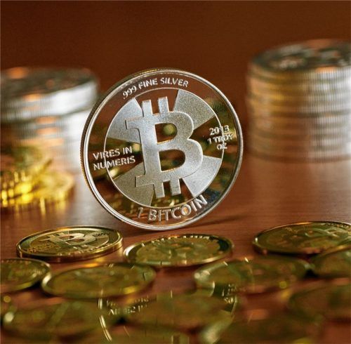 Münzen mit dem Aufdruck „Bitcoin“ stehen und liegen auf einem Tisch. Ein Rosenheimer ist jetzt mit dieser Kryptowährung zum Millionär geworden. Foto dpa