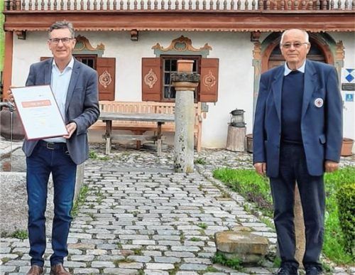 Bürgermeister Georg Huber nahm aus den Händen von Karl-Heinz Zeuner, Vorsitzender des BRK-Kreisverbands (rechts) die Urkunde und die Henry-Dunant-Münze entgegen. Foto re