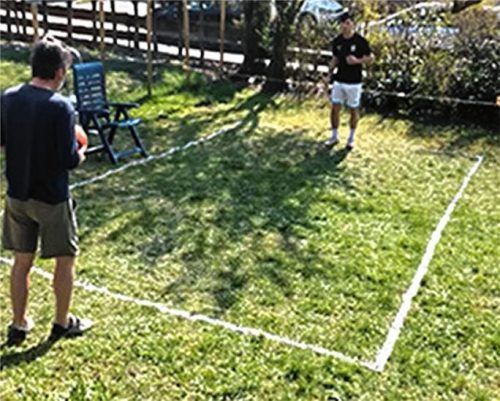 Fußballtennis im heimischen Garten: Das „Netz“ ist eine quer gespannte Schnur, befestigt am Gartenstuhl.