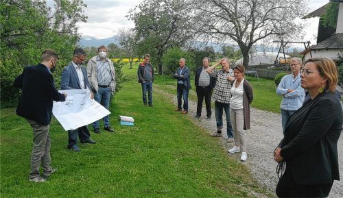Ortstermin auf dem Bauernhof: Während Bürgermeister und Bauamtsleiter in der Brise mit den Plänen kämpfen, schauen sich die Ausschussmitglieder die Lage des geplanten Austragshauses mit Lehrlingsunterkünften und Ferienwohnungen in Fussen an. Foto Hampel