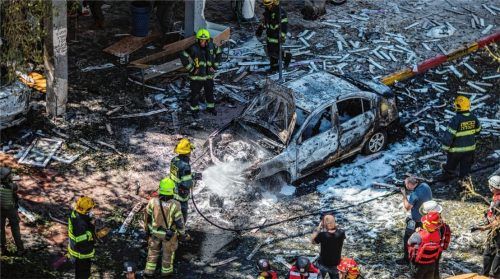 Tausende von Raketen hat die islamistische Hamas auf Israel abgefeuert: Feuerwehrleute löschen in Tel Aviv ein Autowrack vor einem Wohnhaus, das zuvor von einem Geschoss getroffen wurde. Foto dpa