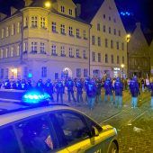 Feiernde werfen Flaschen auf Beamte