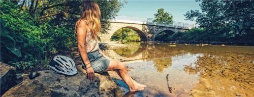 Auf dem Kocher-Jagst-Radweg finden sich immer wieder Möglichkeiten für eine entspannte Radlerpause am Wasser.Foto  djd/Kocher-Jagst-Radweg/Frumolt