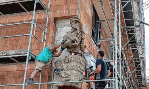 Die ehemalige Karfreit-Statue, der „Bläser“, wurde am Mittwoch an die Gebäudeecke des Seniorenheims in Brannenburg montiert. Foto Thomae