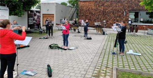 Eine Gruppe des Spielmannszuges Rosenheim probt vor dem Bürgerhaus in Happing. Foto re