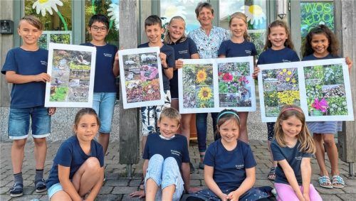 Die elf Schulkinder und Rektorin Marianne Kelnberger mit Foto-Plakaten zum Thema „Biologische Vielfalt in der Schulumgebung“. Foto  Kirchner