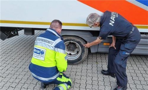 Kontrolle auf Beschädigungen: Maximilian Pink (links) und Hans Kerschbaumer überprüfen ein Rad des Logistikfahrzeugs nach der Fahrt durch den Schlamm im Katastrophengebiet. Foto re