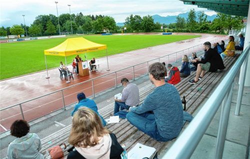 Versammlung in Zeiten von Corona: Schön verteilt nahmen die Vereinsmitglieder des TuS Prien am Jahrestreffen teil, unterm gelben Zelt vorm Regen geschützt sprach die Vorstandschaft.Foto  Berger