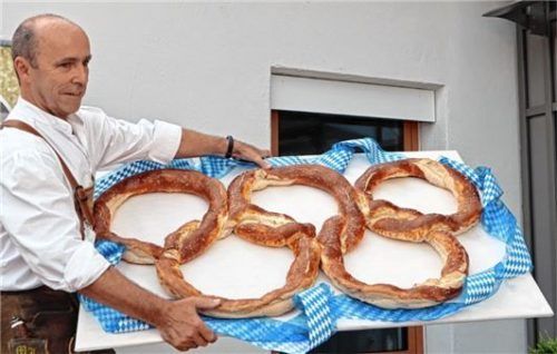 Eine Breze in Form der Olympischen Ringe für die Olympioniken präsentiert Tuntenhausens Dritter Bürgermeister Martin Lurz. Foto Stache