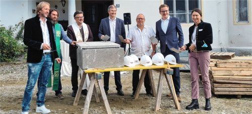 Bei der Grundsteinlegung: (von links) Stefan Mayer, die Pfarrer Michael Krauß und Christoph Rudolph, Mirko Gruber, Peter Dörr, Bürgermeister Christoph Schneider und Theresa Mayer verstauten ein Rohr, gefüllt mit Bauplänen in einem Betonblock. Das von ihnen vermauerte Archiv findet seinen Platz im Fundament des Pavillons.Foto re