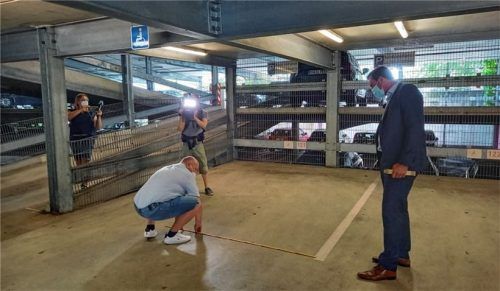 Im Beisein eines Kamerateams: Der Kreisvorsitzende des ACE-Kreisverbands Chiemseer Land, Alexander Oberst (kniend links), und ACE-Pressesprecher Dr. Marc Herzog (rechts) vermessen die Behindertenparkplätze im Parkhaus P7. Breit genug sind sie mit 3,7 Metern, die Länge ist mit 4,8 Meternetwas zu kurz geraten.