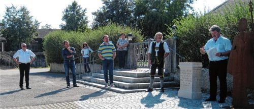 Bürgermeister Sepp Reithmeier (rechts) und Ortsheimatpfleger Sebastian Guggenhuber (Zweiter von rechts) erläuterten die Bedeutung des Pittenharter Römersteins, der nun in Nachbildung östlich des Friedhofs der St.-Nikolaus-Kirche steht. Fotos Graichen
