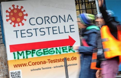 Das Wort „Impfgegner“ wurde mit grüner Farbe auf ein Plakat gesprüht, das den Weg zu einer Corona-Teststelle am Deutschen Museum weist. Foto dpa