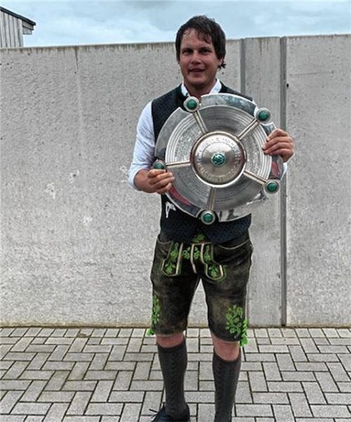 Der Greenkeeper mit der Meisterschale der Bayern-Damen, die im Campus ihre Heimspiele austragen.