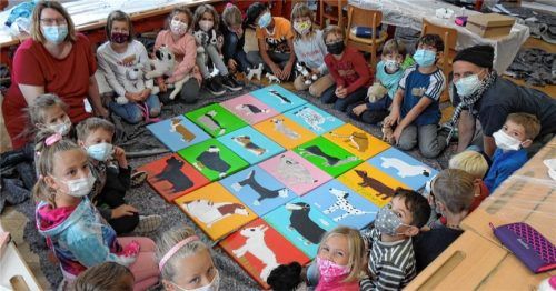 Die Schüler der Klasse 2d haben Hunde gemalt. Gemeinsam mit Lehrerin Susanne Holzer (links) und Thomas Holzer (rechts) haben sie das Kunstprojekt gut gemeistert. Foto re