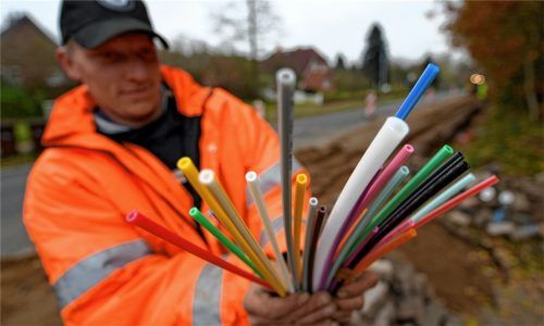 Ein Tiefbauer hält Leerrohre in der Hand, in die später Glasfaserkabel geblasen werden. Der Gemeinderat Rimsting konnte sich nicht darauf einigen, solche Leerrohre künftig verlegen zu lassen. Foto dpa