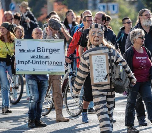 „Wir sind Bürger und keine Impf-Untertanen“ steht auf dem Plakat eines Teilnehmers einer Demonstration gegen die Corona-Politik. Foto dpa