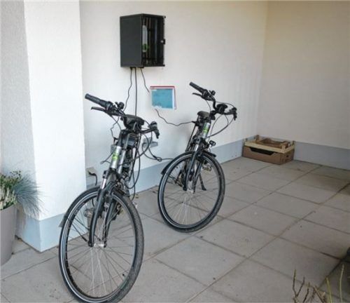 Die beiden E-Bikes, die von der Bevölkerung im Rahmen des Mobilitätsprojekts MüMo ausgeliehen werden können, stehen am Eingang des neuen Kinderhauses. Foto Gillhuber