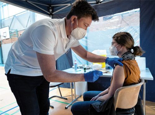 Während einer Sonderimpfaktion wird Marie König in einer Sporthalle von Arzt Sebastian Neumann geimpft. Foto dpa