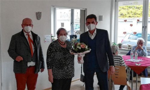 Zum Dank ein Blumenstrauß: Rosenheimer Stadtdirektor Michael Keneder (rechts) ehrt zusammen mit Martin Wollny, Leiter des Sozialamtes Rosenheim, die Organisatorin Maria Francese für 20 Jahre Kaffeenachmittag im Bürgerhaus „Miteinander“.Foto Sautter