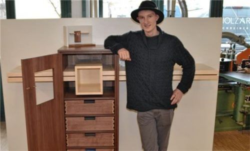 Der Absolvent Felix Wiedmann mit seinem Meisterstück, einem Dielenschrank. Foto re